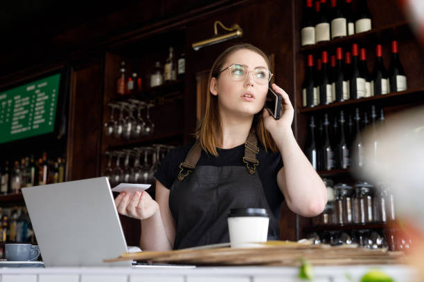 istock Young Female Bar Owner Working On Phone and Laptop 1095889062