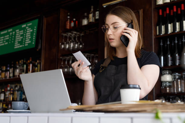 istock Young Female Bar Owner Working On Phone and Laptop 1095889106