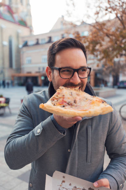 istock Man eating slice of pizza 1095890008