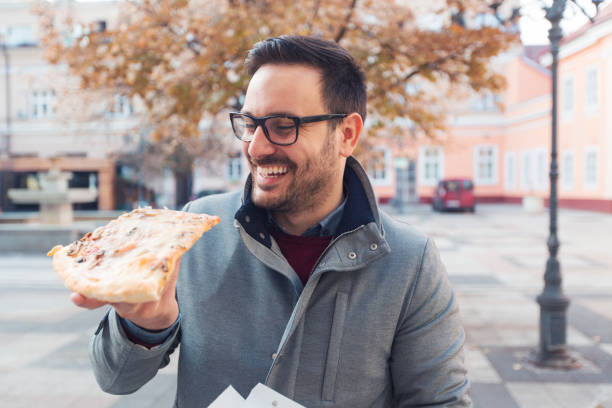 istock Man eating slice of pizza 1095890118