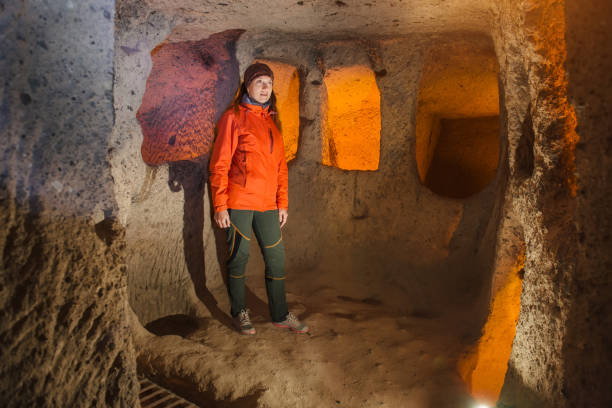 istock Young tourist woman explore ancient underground cave 1095895082