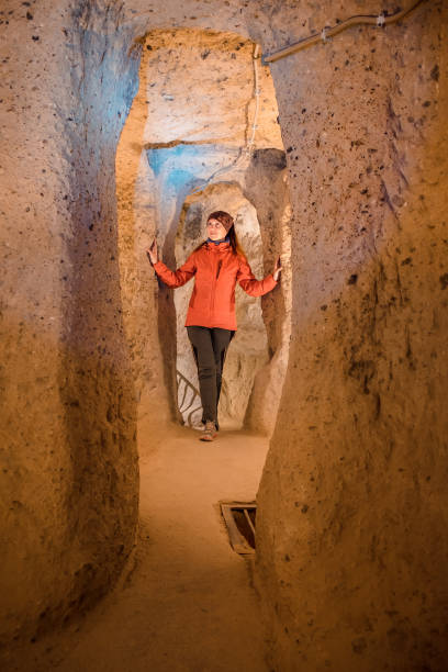 istock Young tourist woman explore ancient underground cave 1095895138
