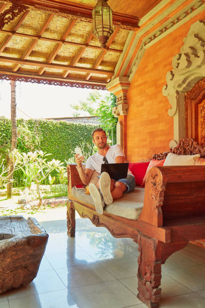 istock Man with coffee / tea and laptop on a home porch. 1095897996