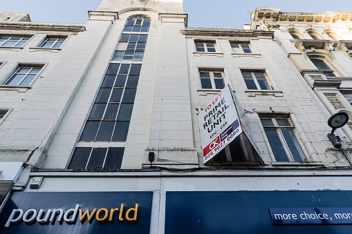 Belfast, United Kingdom - January 17, 2019: The facade of an abandoned Poundworld retail store on Donegall Place in the heart of the city's main retail area.  Poundlworld was established in the UK in 1974 as a discount variety store (selling most goods for £1).  It diversified into multi-priced items by the 2000s, but could not compete with its rivals in the discount sector and was declared bankrupt in 2017.  It's demise reflects the wider decline of retailing in British and Irish city centres and the squeeze on low margins in the discount end of the retail market after the financial crash of 2008.