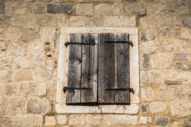 istock Closed old wooden window on stone wall 1095900624