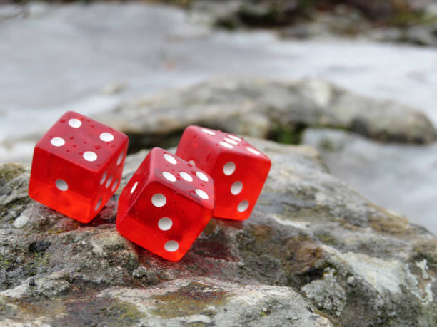 istock Red dice with water drops on the rocks in the seacoast 1095904720