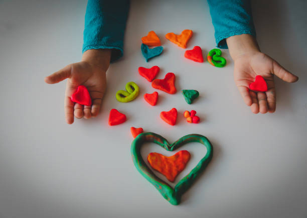 niña haciendo corazones de barro, manualidades del día de san valentín - food child childs play clay craft fotografías e imágenes de stock