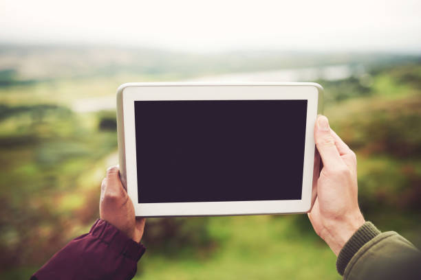 Cropped shot of an unrecognizable couple holding a tablet together outdoors