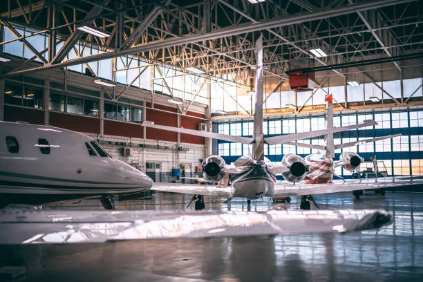 piccoli aerei a doppio motore immagazzinati in un hangar per aeromobili - hangar foto e immagini stock