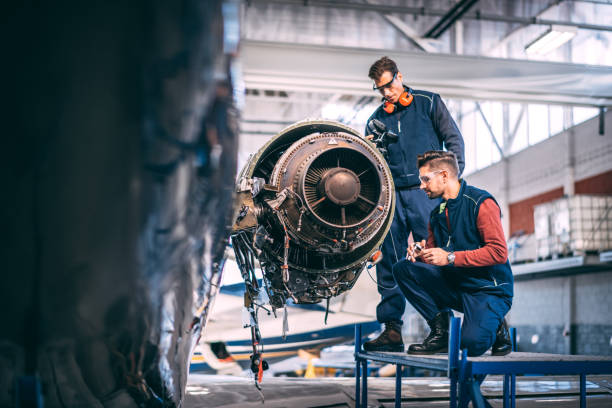 istock Two technicians working together on a disassembled jet engine of a small plane in an aircraft maintenance hangar 1095914662