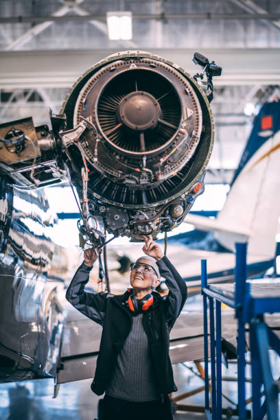 Elderly female engineer working on an aircraft jet engine in a hangar Senior female engineer doing some maintenance on an aircraft jet engine in a hangar. plane hand tool stock pictures, royalty-free photos & images
