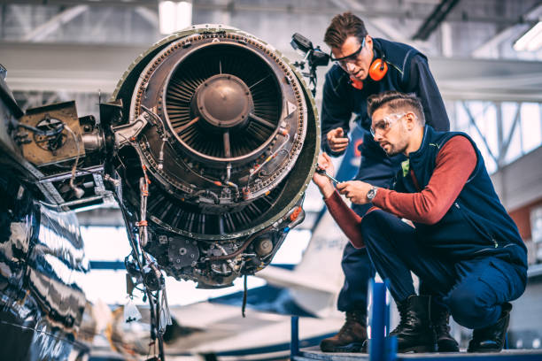 istock Two engineers working together on a partially disassembled jet engine of a small airplane in an aircraft maintenance hangar 1095914680