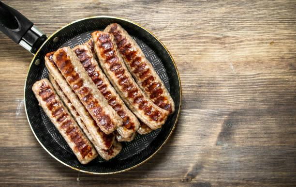 istock Fried sausages in a frying pan. 1095922040