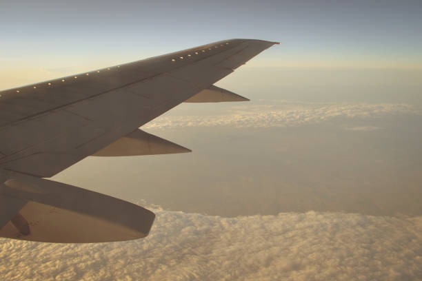 istock Wing of an airplane flying above the sunset clouds 1095923782