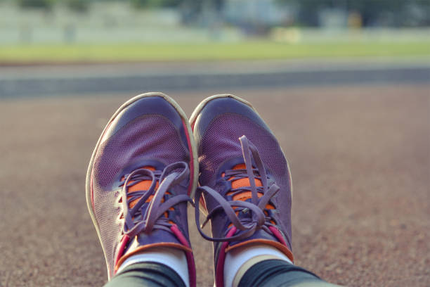 istock Unrecognizable young runner tying her shoelaces. Studio shot on wooden floor background. 1095927926