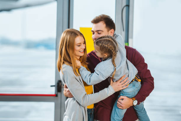 istock cheerful family smiling while hugging in airport 1095928536