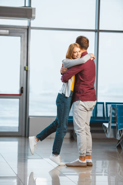 istock attractive woman hugging boyfriend in waiting hall 1095928792