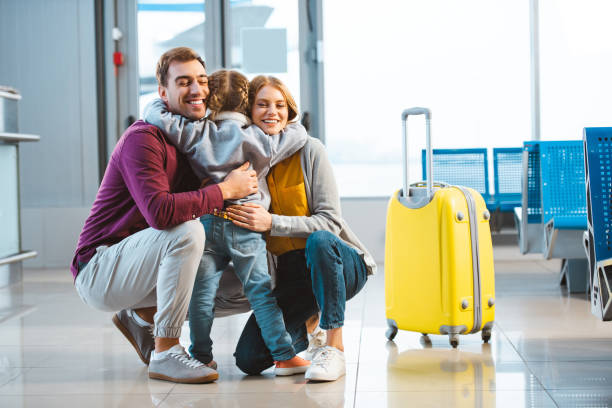 back view of child hugging mom and dad in  waiting hall back view of child hugging mom and dad in  waiting hall airport hug stock pictures, royalty-free photos & images