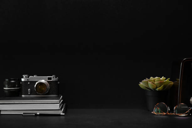istock Dark leather desk with vintage camera, home office supplies and copy space 1095929064