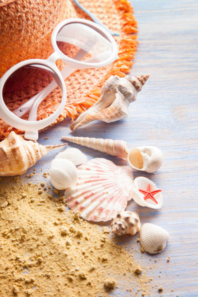 istock beach accessories glasses hat cockleshells on wood deck. 1095929728