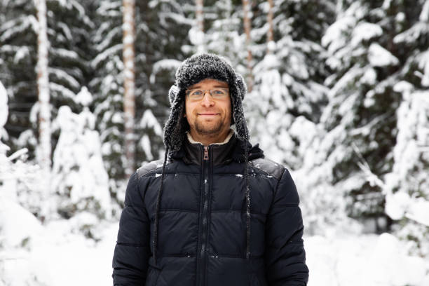 istock Man in fur winter hat with ear flaps smiling portrait 1095940648