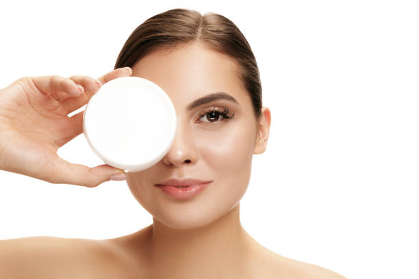 istock Cute girl preparing to start her day. She is applying moisturizer cream on face. 1095942616