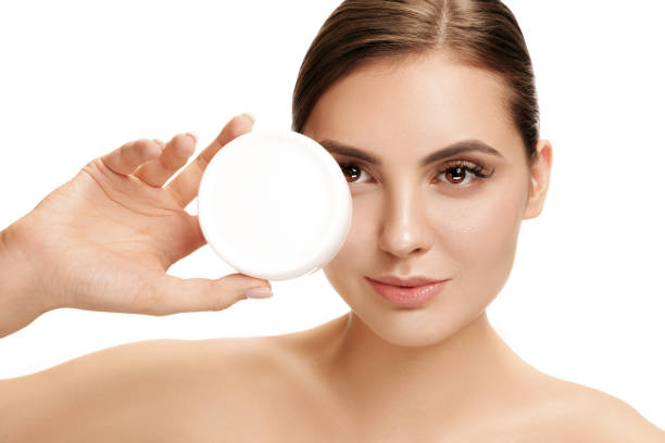 istock Cute girl preparing to start her day. She is applying moisturizer cream on face. 1095942624