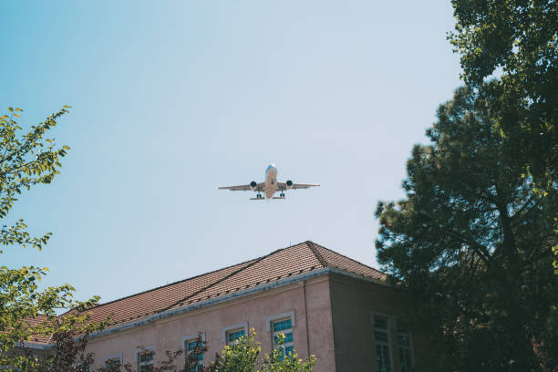Plane flying over residential building stock photo