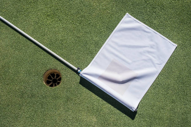 campo de golf con el agujero vacío y bandera blanca - practicing golf putting golf flag fotografías e imágenes de stock