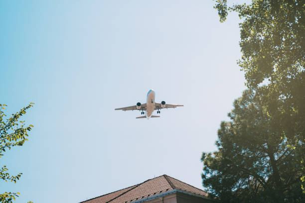 istock Plane flying over residential building 1095948958
