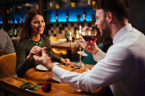 Couple holding hands during romantic dinner in a restaurant Couple holding hands during romantic dinner in a restaurant date night romance stock pictures, royalty-free photos & images