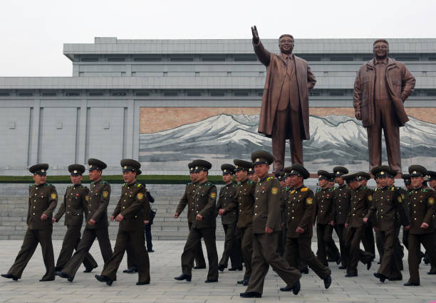 North Korean leaders and soldiers April 13, 2018. Mansudae Grand Monument, Pyongyang, North Korea.
Soldiers visiting the huge statues of North Korean leaders. 
Kim Il-Sung and Kim Jong-Il have special posters and monuments in different parts of the city. The most important of these monuments is the giant sculptures of North Korea's founding leader Kim Il-Sung and his son Kim Jong-Il. All tourists who come to visit the country have to come here and show their respects. cold war photos stock pictures, royalty-free photos & images