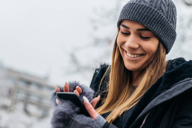 istock Pretty woman in winter clothes text messaging 1095960548