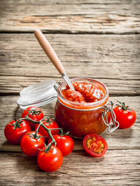 istock Tomato sauce in a glass jar with fresh tomatoes. 1095964974