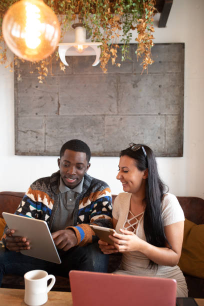 istock Mixed race couple in cafe having fun with their tech devices 1095967030