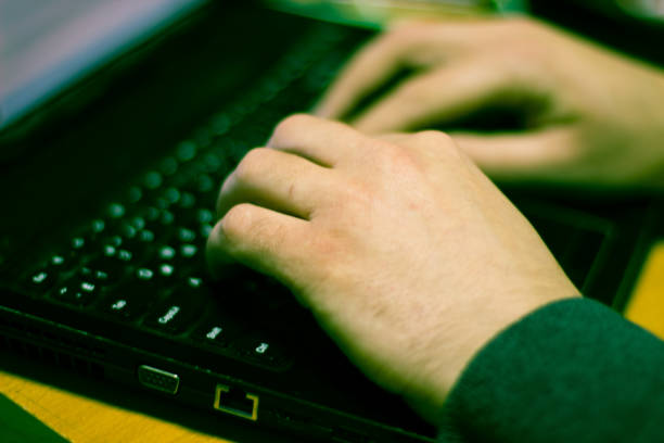 istock The hands of the programmer, he working on a laptop with a Russian keyboard. The frame is in a selective focus. 1095973544