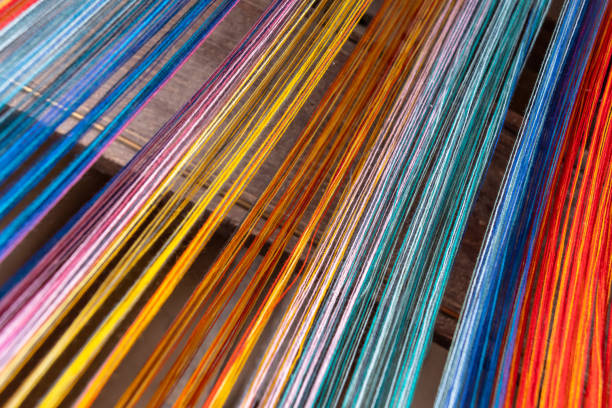 Colored threads of an ancient wooden loom .