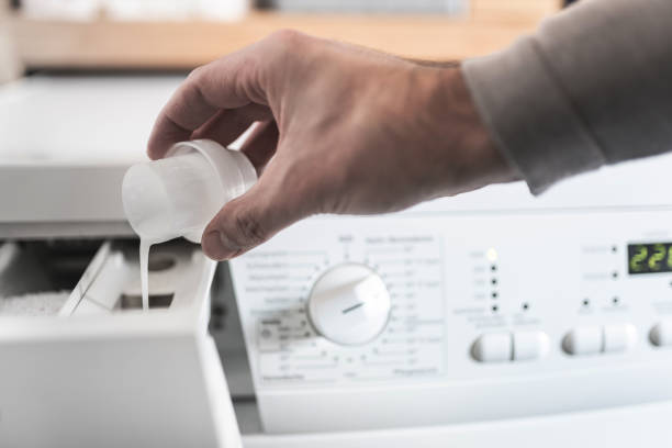 istock man using dosing aid to fill fabric softener into washing machine 1095975590