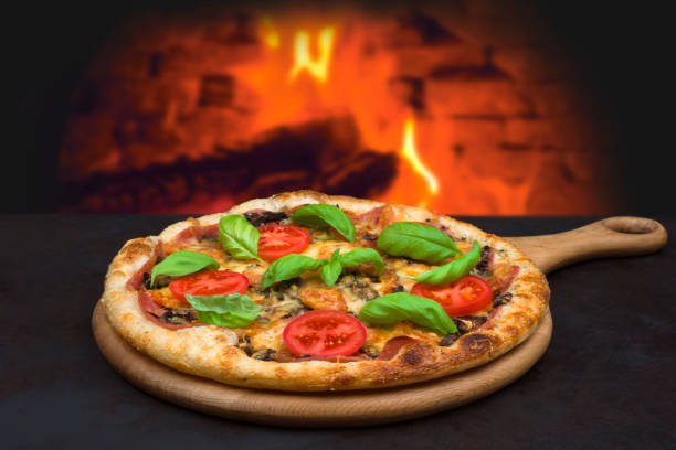 Traditional baked pizza on background of blurred brick oven fire