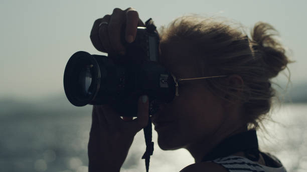 istock Female photographer on a sailboat. Sunlight reflection 1095979256