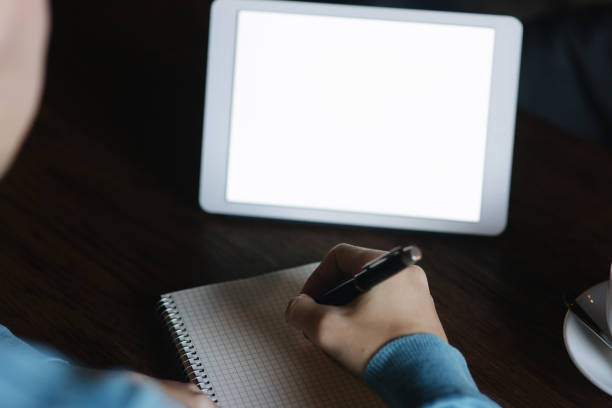 istock Man is sitting in cafe and using a tablet. Student spend time in cafe and drink a coffee. He study and note helpful information 1095979728
