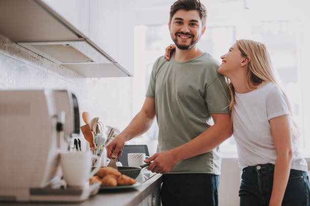 istock Happy young couple preparing breakfast together in light interior 1095983514