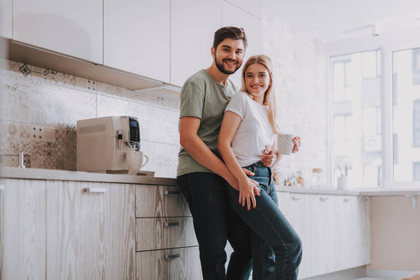 istock Joyful couple standing in bright spacious kitchen in morning 1095983528