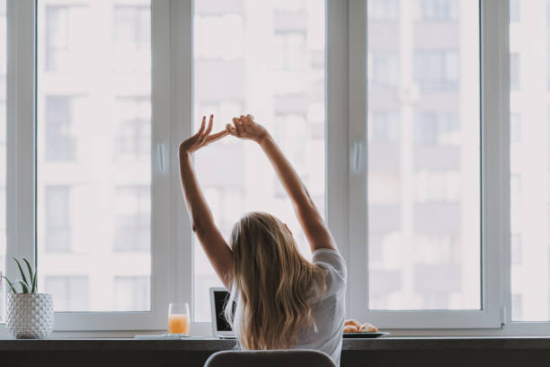 mujer ocupada haciendo gimnasia para relajar el cuerpo - sunday fotografías e imágenes de stock