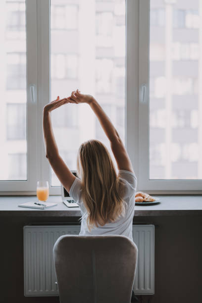 istock Blonde girl sitting at computer and stretching 1095983570