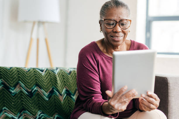 Senior women at home using tablet Senior women using tablet for smart home application old woman smiling tablet stock pictures, royalty-free photos & images