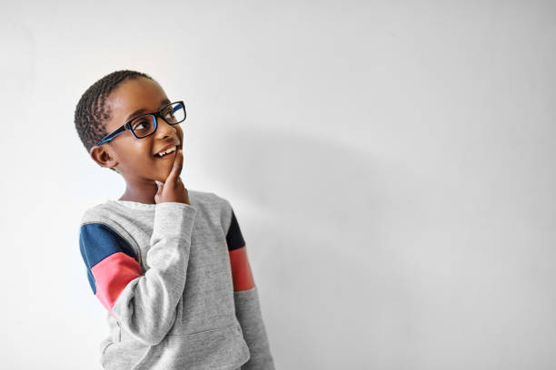 Imagination can take you anywhere Shot of an adorable little boy looking away thoughtfully black nerd stock pictures, royalty-free photos & images