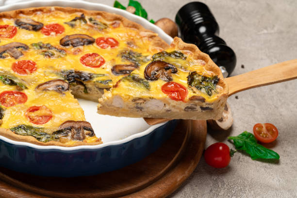 istock Baked homemade quiche pie in ceramic baking form and slice on wooden paddle 1095997420