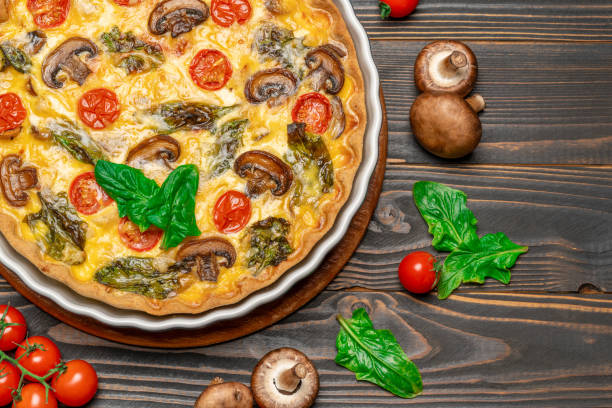istock Baked homemade quiche pie in ceramic baking form on concrete background 1095997452