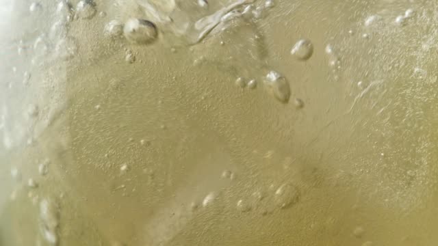 Fizzy lemonade drink pouring into glass